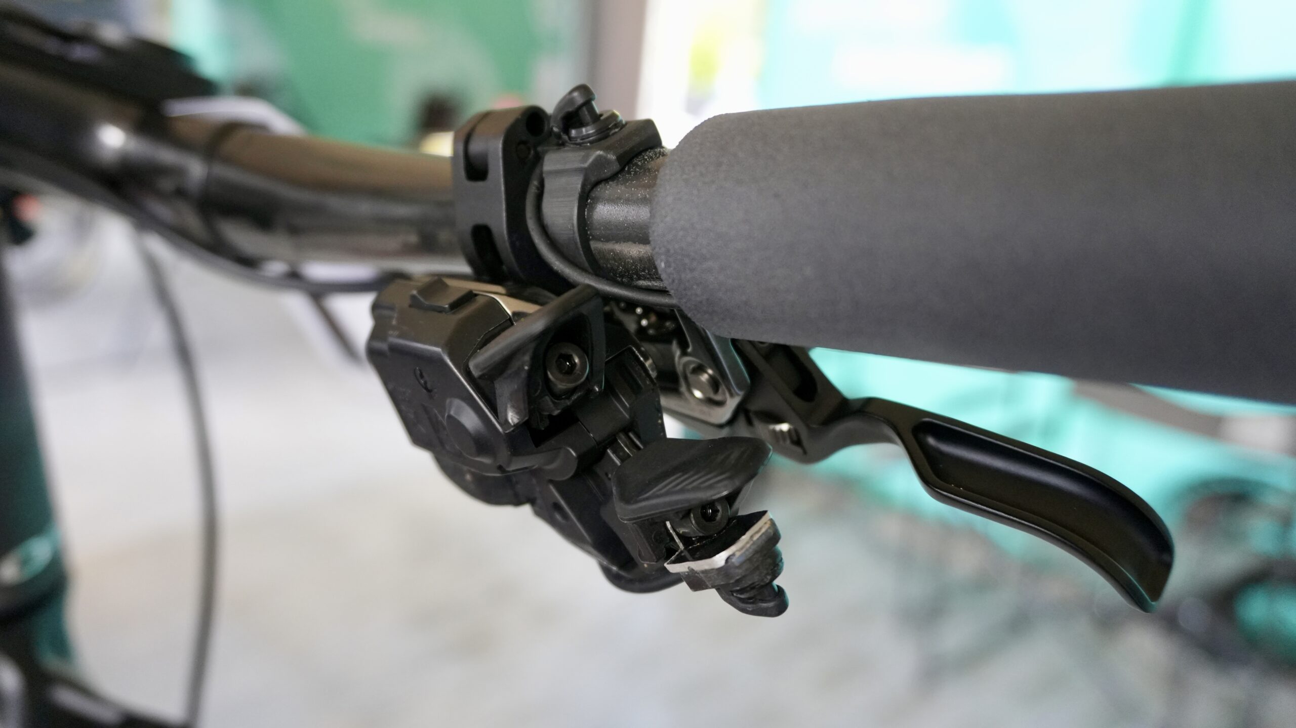 Shifter satellite Di2 encaixado sobre o XTR para acionamento pelo indicador — hack Orbea Factory XCO 2026