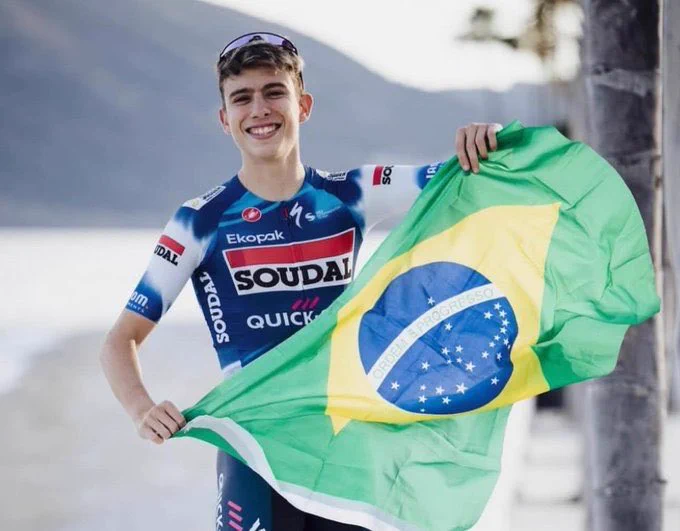 Henrique Bravo com a bandeira do Brasil e o uniforme da Soudal Quick-Step